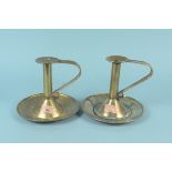 A near pair of large Arts and Crafts brass chambersticks with wide circular dished bases and