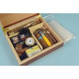 A humidor with cigars, some wrapped, some loose,