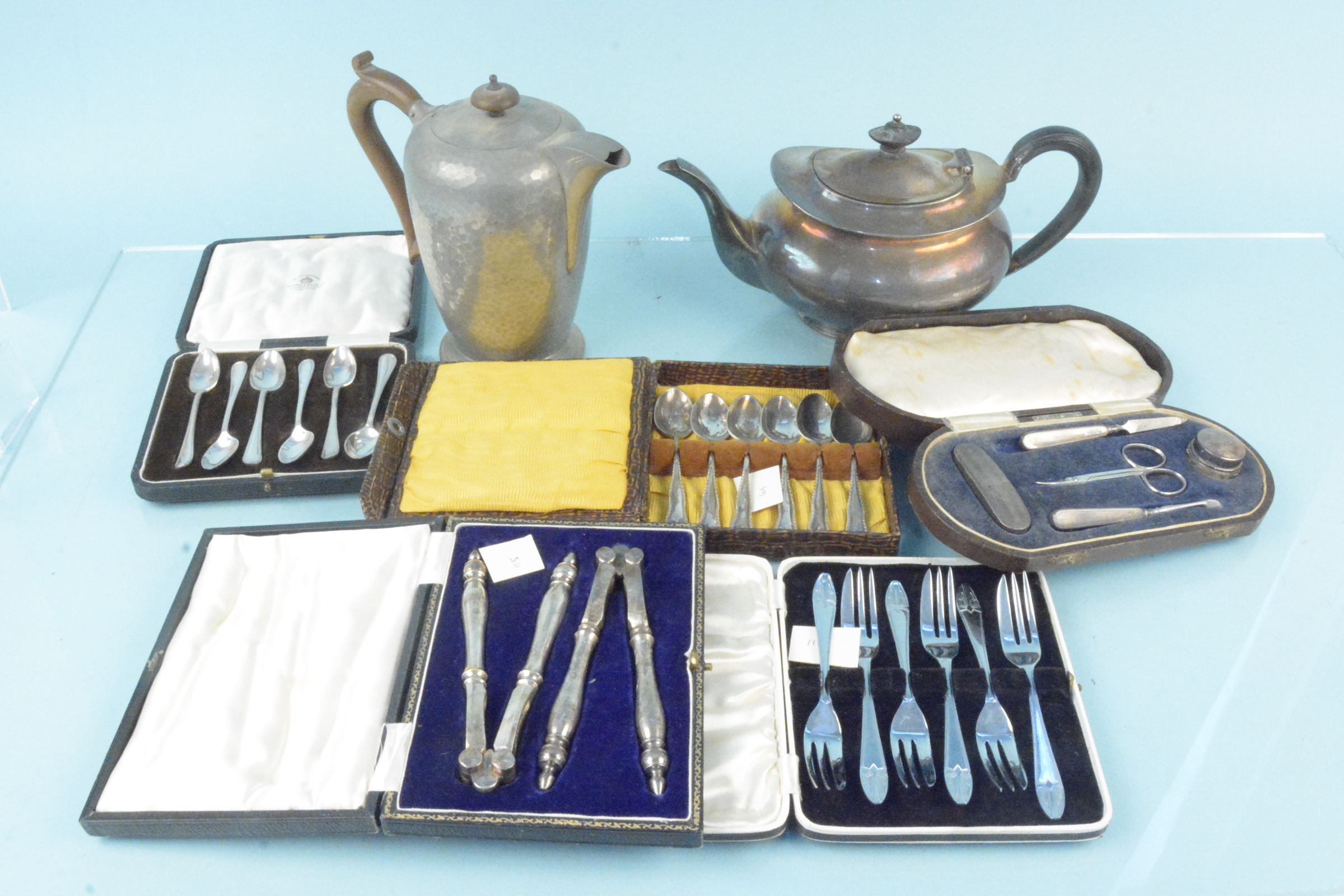 A cased silver mounted manicure set including buffer and lidded glass jar plus two cased sets of