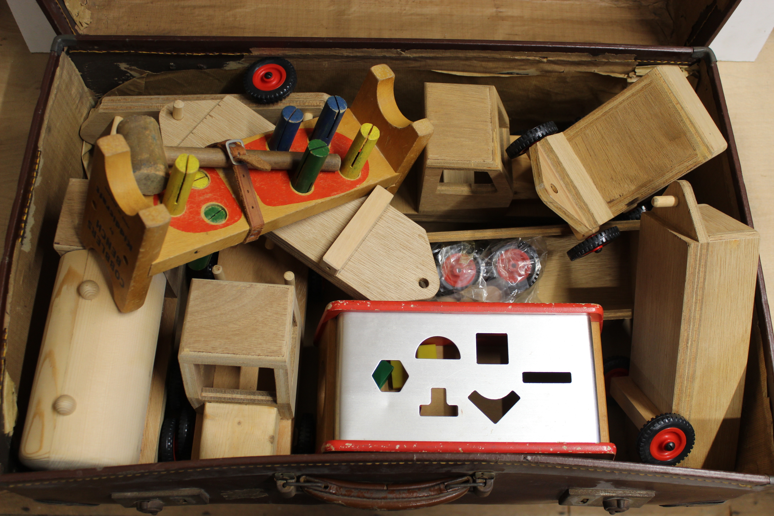 A vintage suitcase full of wooden childrens toys