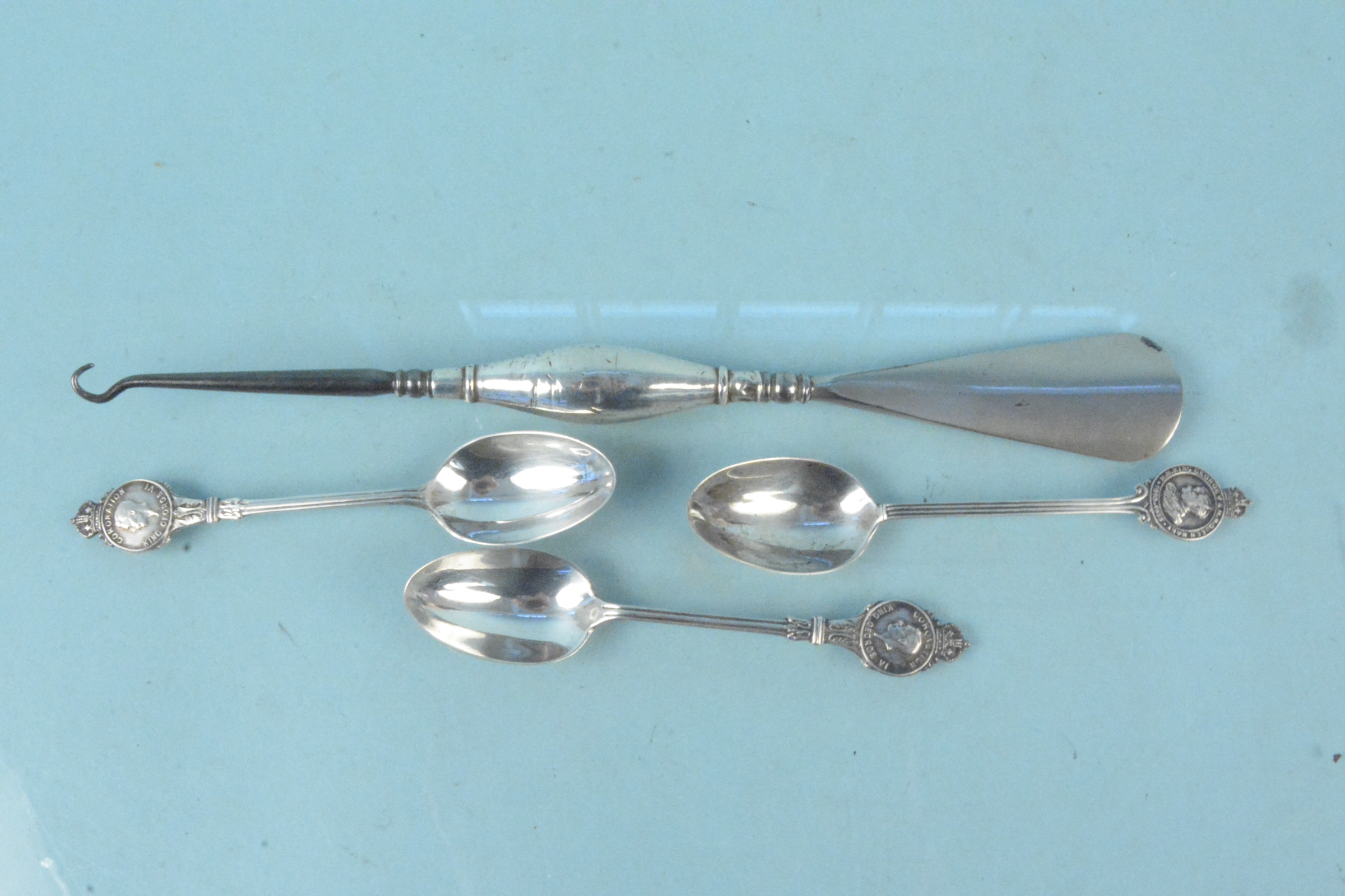 An unusual silver handled shoe horn and button hook together with three silver Royal commemorative