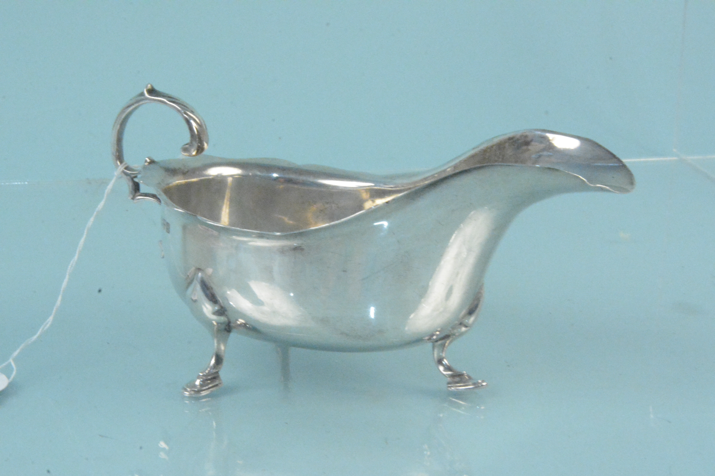 A silver sauce boat on three hoof feet (as found), hallmarked Chester 1911, maker Barker Brothers,