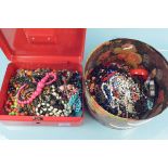 A metal money box containing a quantity of coloured beaded jewellery plus a hat box of costume