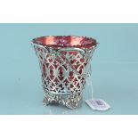 A Victorian pierced silver swing handled basket on four feet with cranberry glass liner,