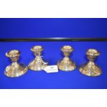 Set of Four Small Silver Candlesticks (filled)