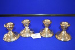 Set of Four Small Silver Candlesticks (filled)