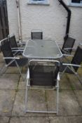 *Metal Framed Glass Topped Patio Table with Six Folding Chairs