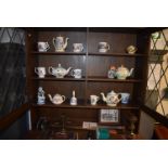 Contents of Wall Unit to Include Three Shelves of Teapots, Mugs, and Other Pottery, Old Cricket Bat,