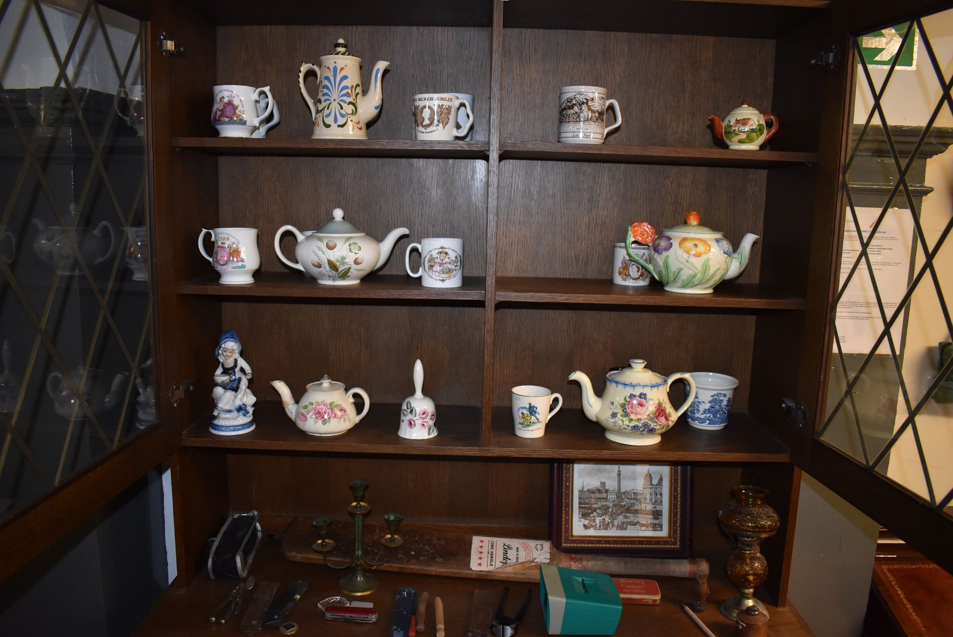 Contents of Wall Unit to Include Three Shelves of Teapots, Mugs, and Other Pottery, Old Cricket Bat,
