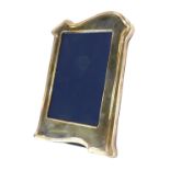 A silver photograph frame, the arched top on a blue velvet back, Sheffield 1996, 19cm high.