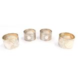 Four napkin rings, comprising a pair of engraved napkin rings with oval shield and floral detailing,