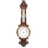 A Victorian oak aneroid wheel barometer, with thermometer, the case carved with leaves and c