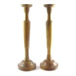 A pair of turned wooden candle sticks, each with black pricket top, 60cm high.