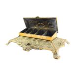 A Victorian brass desk stand, the hinged box top embossed with classical urn, flowers and foliate