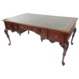 A Chippendale style mahogany partner's desk, with a triple section gilt tooled green leather top,