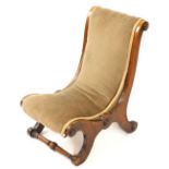 A Victorian mahogany nursing chair, upholstered in over stuffed brown draylon, raised on X frame