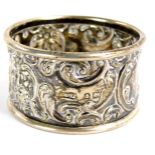 A George V silver napkin ring, with rococo scroll and mask detailing, reserve panel bearing the