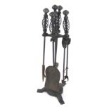 A cast iron fireside companion set, the main stem on tripod base with twist design handles and