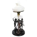 An early 20thC spelter oil lamp, cast as three standing cherubs with ribbons around a central spiral