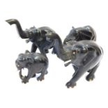 Four ebony models of elephants, two with trunks raised, largest 24cm wide.