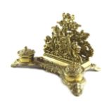 A Victorian brass desk stand, with letter rack, back section depicting putto and cornucopia, fronted