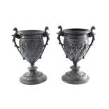 A pair of Victorian cast iron urns, of twin handled baluster form, relief decorated with a band of