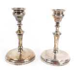 A pair of George V loaded silver candlesticks, each of turned form, London 1915, 15cm high.