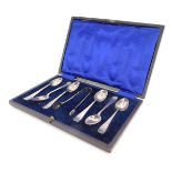 A George V silver shell pattern coffee set, comprising six teaspoons and matching sugar tongs,