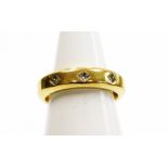 An 18ct gold wedding band, set with three tiny diamonds in a star setting, with applied adjuster
