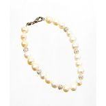 A cultured pearl bracelet, of graduated design with sparkle set bead breakers, on a string strand,