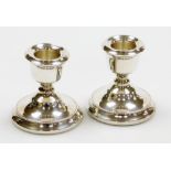 A pair of Elizabeth II silver squat candle sticks, by A T Cannon Ltd, Birmingham 1973, loaded bases,