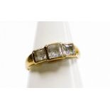 A 9ct gold three stone dress ring, set with three ash cut czs, in rub over setting, on a plain band,