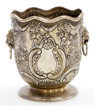 A Victorian silver bottle holder of Monteith form, with a waved rim, the body embossed with bows,