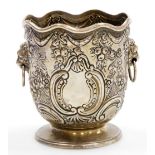 A Victorian silver bottle holder of Monteith form, with a waved rim, the body embossed with bows,