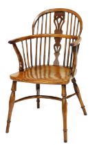 A 19thC yew and elm Windsor chair, with a pierced splat, spindle turned supports and a solid seat,