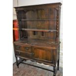 An oak dresser, with plate rack back, on twist column supports with two drawers and single cupboard,