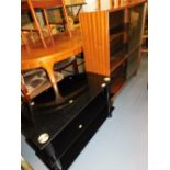 A three tier glass television stand, 82cm wide, and a glaze fronted bookcase, 99cm wide.