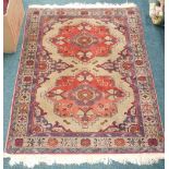 A Turkish style rug, with two medallions in orange on a cream ground with multiple borders, 94cm by