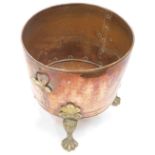 A late 19thC hammered copper coal bucket, with brass mount on hairy paw feet, 39cm high, 42cm wide.