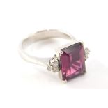 An 18ct gold dress ring, with central asher cut ruby, 11mm x 8.4mm x 4.8mm, with three round brillia