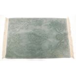 A Chinese green jade coloured rug, with raised decoration of flowers, leaves, etc., 177cm x 124cm.