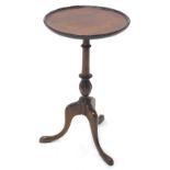 An early 20thC walnut tripod wine table, the dish top with a beaded border, above a turned and carve