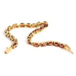 A bracelet, claw set, with oval red stones, marked 14k, 19cm long, 5.6g all in.