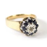 A ladies 9ct gold dress ring, florally claw set with small sapphires centred by a white stone, size