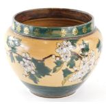 An early 20thC Royal Doulton stoneware jardiniere, of circular form decorated with flowers on a crea