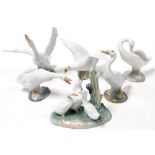 Five Lladro porcelain figures of geese, in various standing poses, together with a Nao figure group