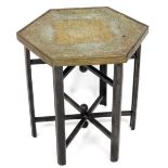 An early 20thC Indian brass tray top occasional table, the hexagonal top engraved and embossed with