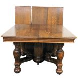 A late Victorian oak draw leaf dining table, with three additional leaves, having a central turned a