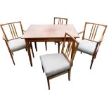 A Russell of Broadway mid century teak dining table and chairs, the draw leaf dining table raised on