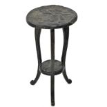 An early 20thC Japanned carved oak two tier side table in the manner of Liberty, the top and under t